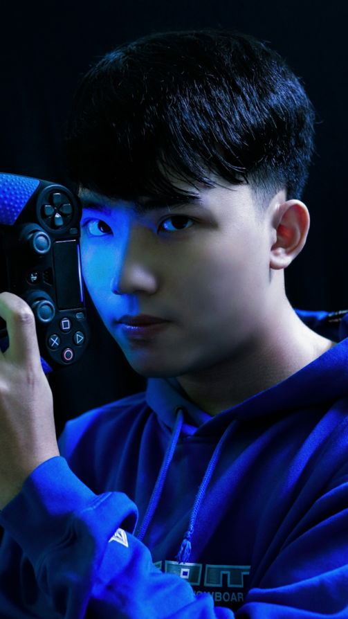 boy in blue long sleeve shirt holding black game controller
